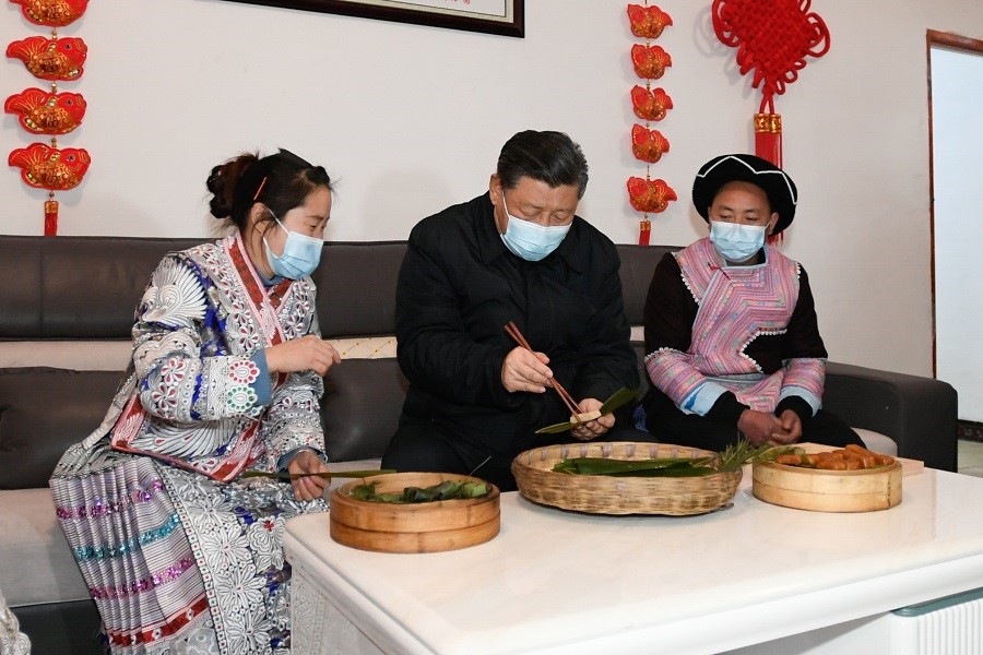 2021年2月3日下午，習(xí)近平在貴州畢節(jié)市黔西縣新仁苗族鄉(xiāng)化屋村苗族村民趙玉學(xué)家,，同一家人邊聊家常邊制作當(dāng)?shù)貍鹘y(tǒng)節(jié)日食品黃粑,。新華社記者 李學(xué)仁 攝