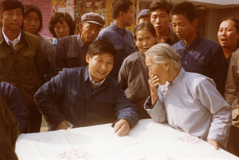 1983年,，時(shí)任河北正定縣委書記的習(xí)近平（前排居中）,，臨時(shí)在大街上擺桌子聽取老百姓意見。
