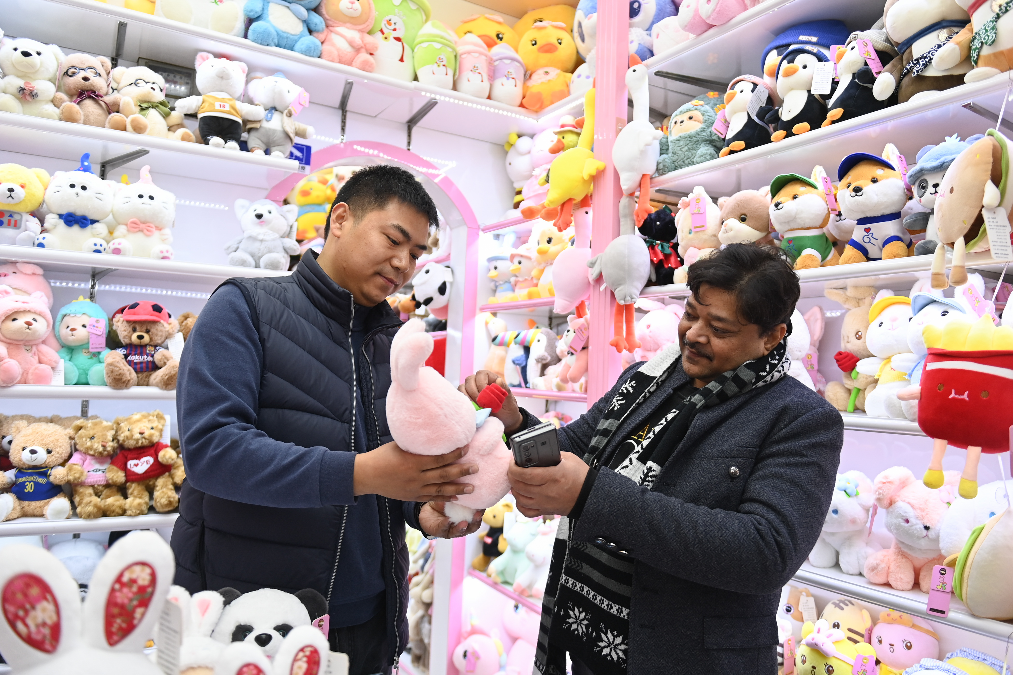 2023年2月2日,，來自印度的客商（右）在義烏國際商貿(mào)城的一家玩具店鋪內(nèi)選購,。